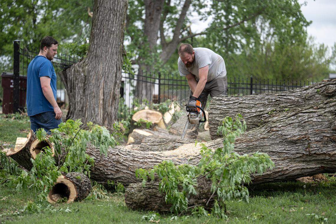 Volunteers helped a resident with cleanup of a large, fallen tree on a residential lot in the 600 block of East Bodine St., in Clinton Missouri, on Thursday, April 16, 2026, one day after a tornado touched down in Henry County.  