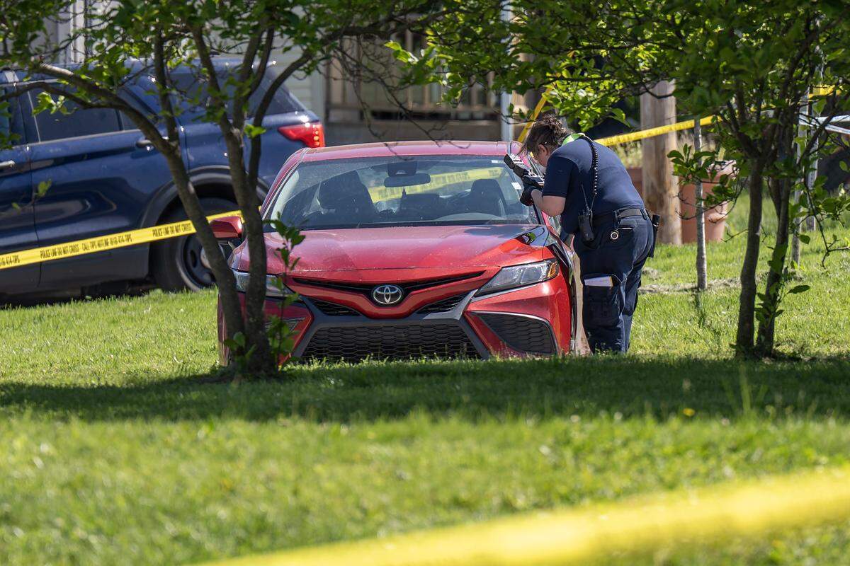 A Kansas City police officer photographs a vehicle near the scene of a shooting by the Tony Aguirre Community Center on Sunday, May 3, 2026, in Kansas City.