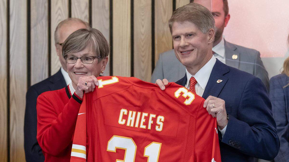Gov. Laura Kelly presents Kansas City Chiefs owner Clark Hunt with a jersey in Topeka on Monday, Dec. 22, 2025, after she announced the team’s move across the state line to Kansas City, Kansas.