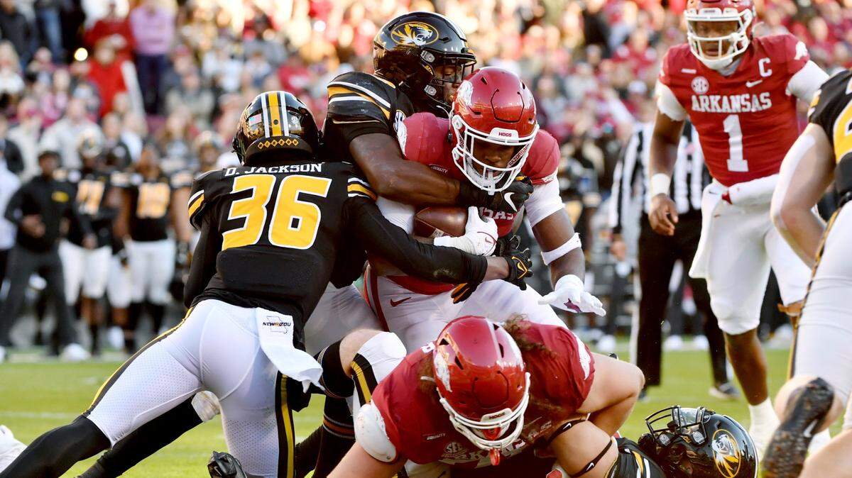 Arkansas running back Raheim Sanders (5) pushes past Missouri defenders DJ Jackson (36) and Chad Bailey (33) to score a touchdown during the first half of an NCAA college football game Friday, Nov. 26, 2021, in Fayetteville, Ark. (AP Photo/Michael Woods)