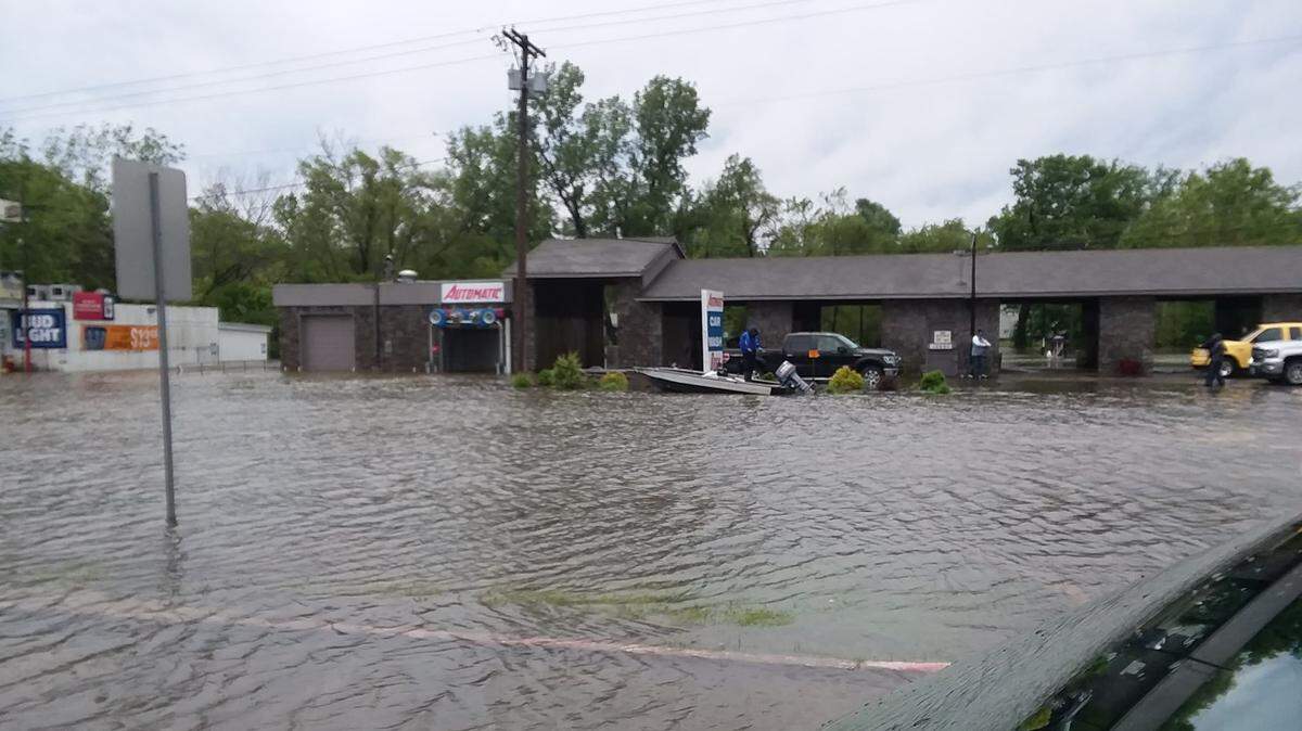 Paul Wrabec, local car wash owner, jokingly put his boat in the water to fish at the flooded out intersection near U.S. Highway 24 in Independence.