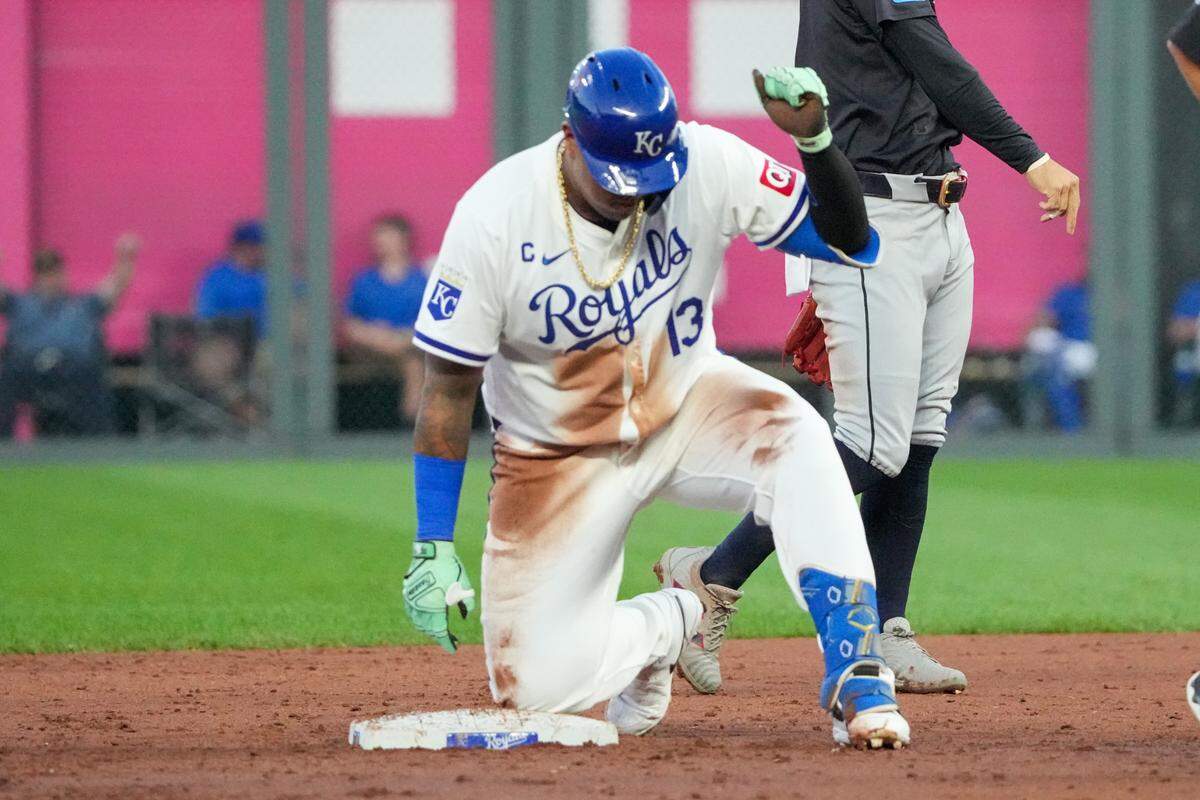 Kansas City Royals first baseman Salvador Perez (13) celebrates against the Cleveland Guardians at second base after hitting a double in the third inning at Kauffman Stadium.