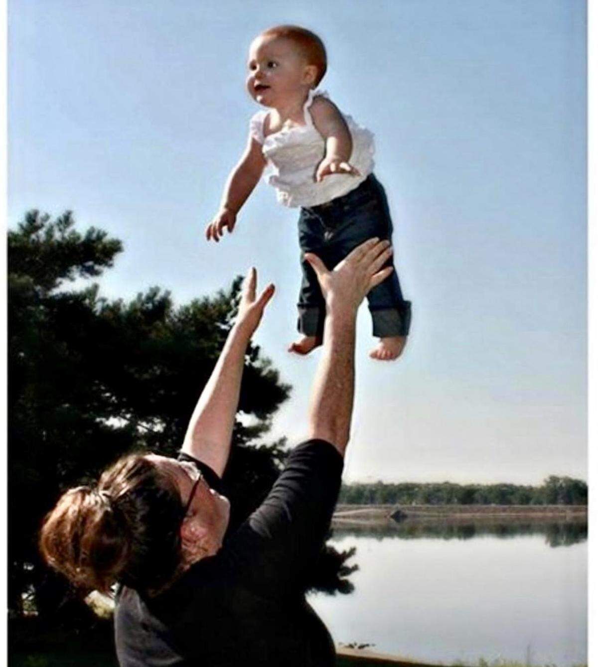Jessica Tangen, who died at a Chiefs training camp practice this summer, tosses her daughter Kyla in the air.