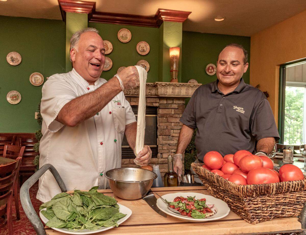Jasper Mirabile, left, creates mozzarella tableside with the help of his nephew Jasper Mirabile III. They served the cheese in the caprese salad in front of them.