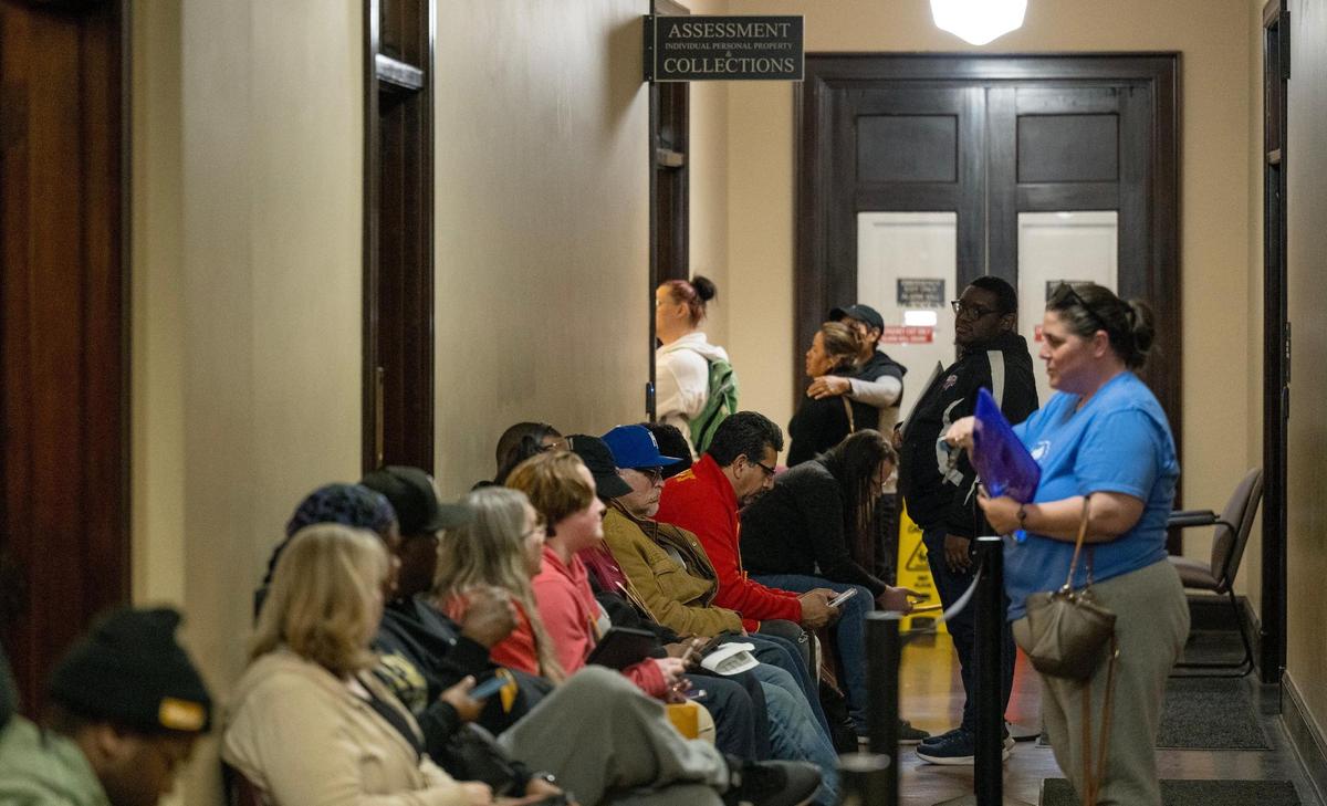 People wait in line to work with staff at the Jackson County Assessment office on Friday, March 29, 2024, in Independence, Missouri.