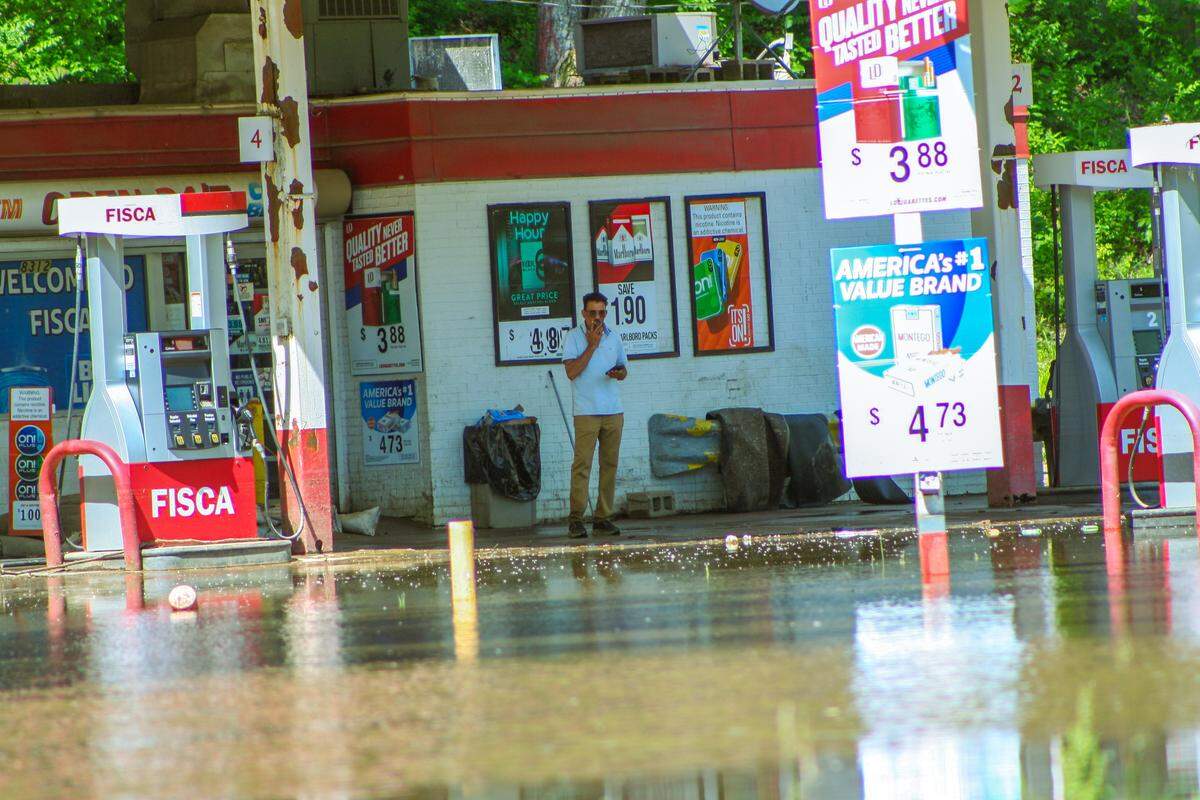 A man looks at the flooding at the 23rd Street Trafficway and Television Place intersection from the Fisca gas station on June 2.
