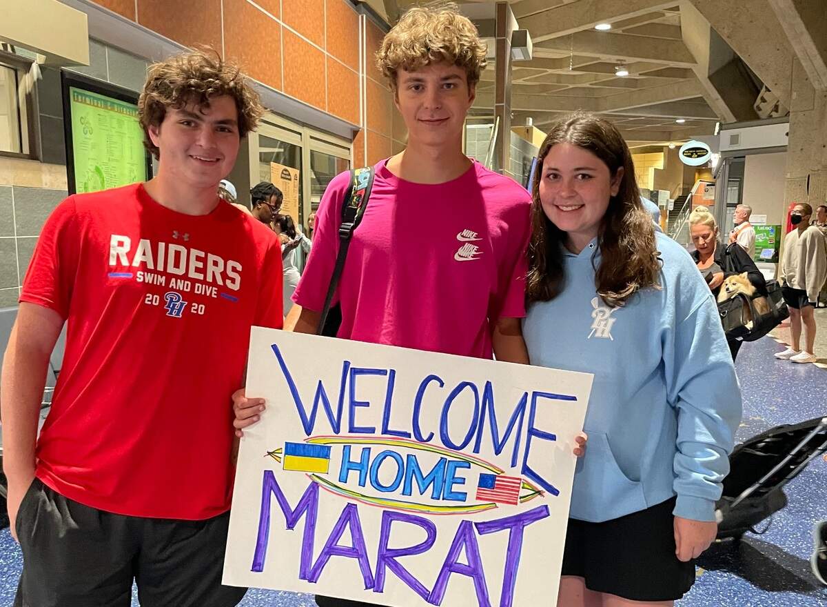 Ukrainian swimmer Marat Usov, center, is welcomed to America by Zach and Eliza Berg, his new host brother and sister, when the three met for the first time as Usov arrived at KCI.
