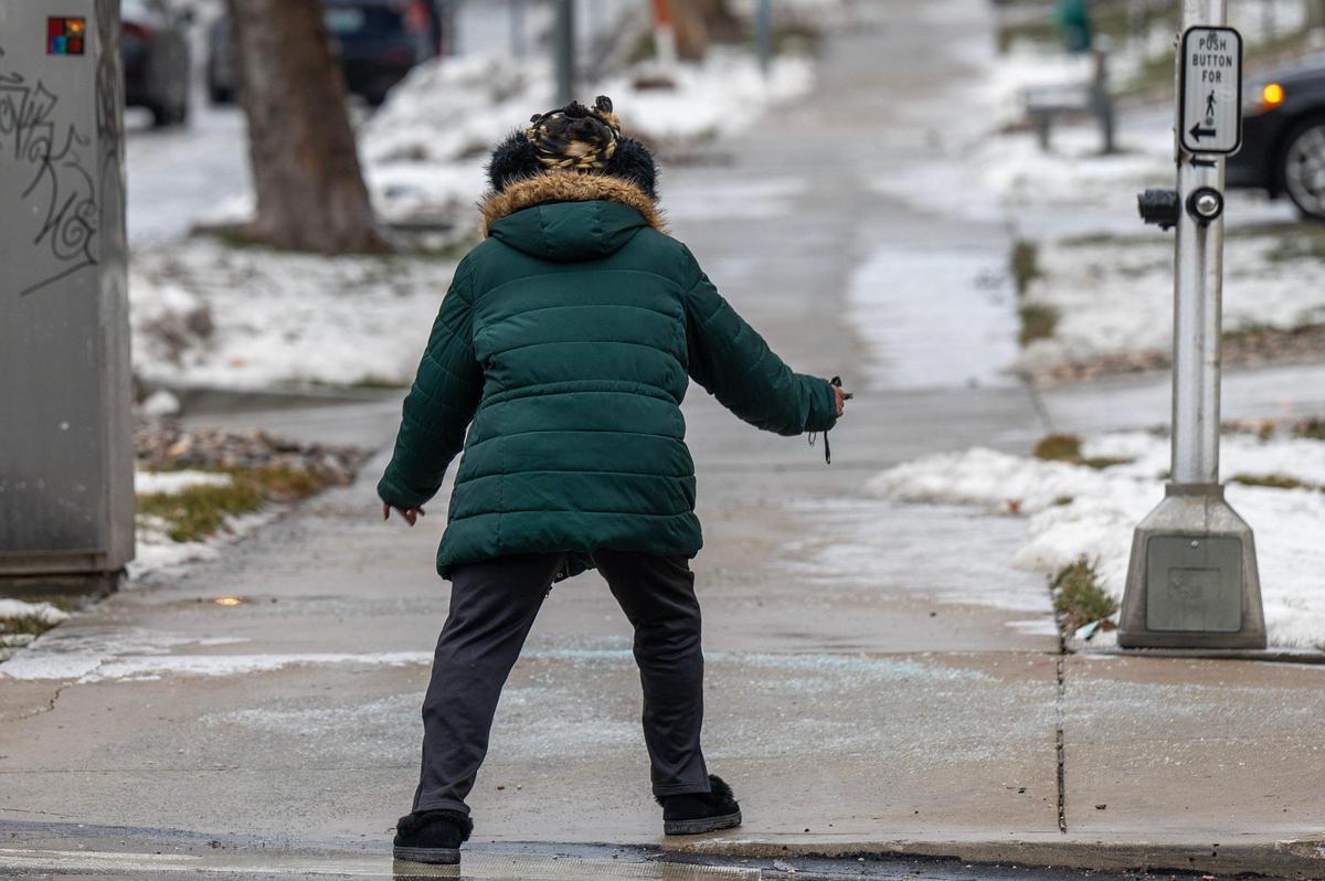 Mary McDaniel carefully navigates an icy sidewalk along Armour Boulevard during her morning walk on Monday, Jan. 22, 2024, in Kansas City.