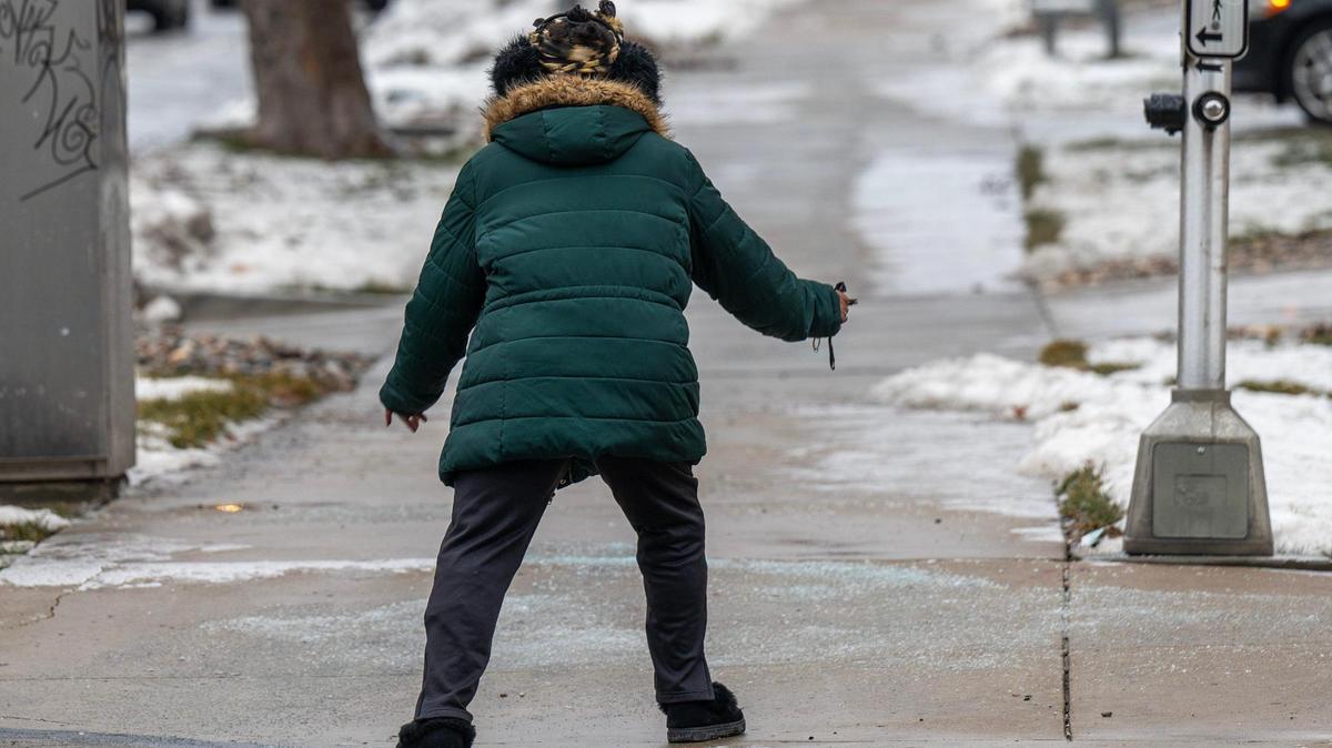 Mary McDaniel carefully navigates an icy sidewalk along Armour Boulevard during her morning walk on Monday, Jan. 22, 2024, in Kansas City.