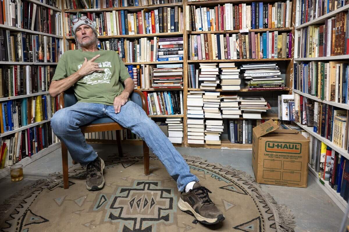 David Steel, owner of Steel's Used Books, sits for a portrait at the shop near a section of books on Tuesday, June 23, 2026, in Kansas City.