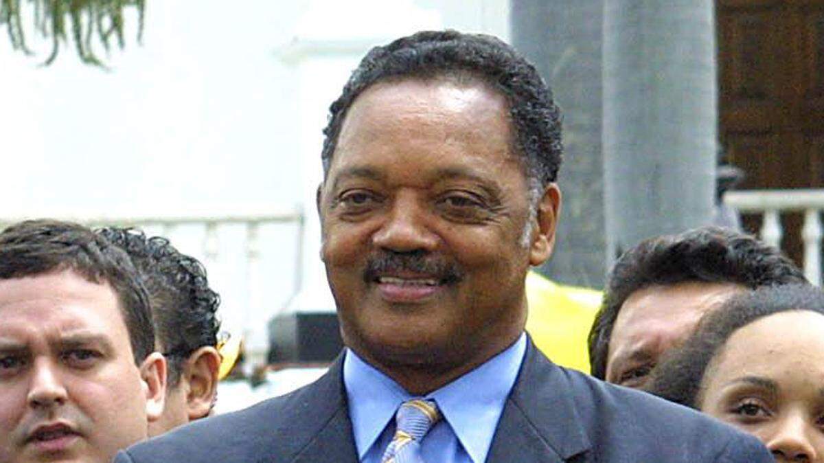 US civil rights activist Reverend Jesse Jackson (R) applauds after hearing a speech, accompanied by Venezuelan Vice President Jose Vicente Rangel (L) and by Nicolas Maduro (C), President of the National Assembly  28 August, 2005 in Caracas. During his three-day visit to Venezuela, Jackson will meet President Hugo Chavez, as well as politicians and community leaders. AFP PHOTO STR (Photo by AFP via Getty Images)