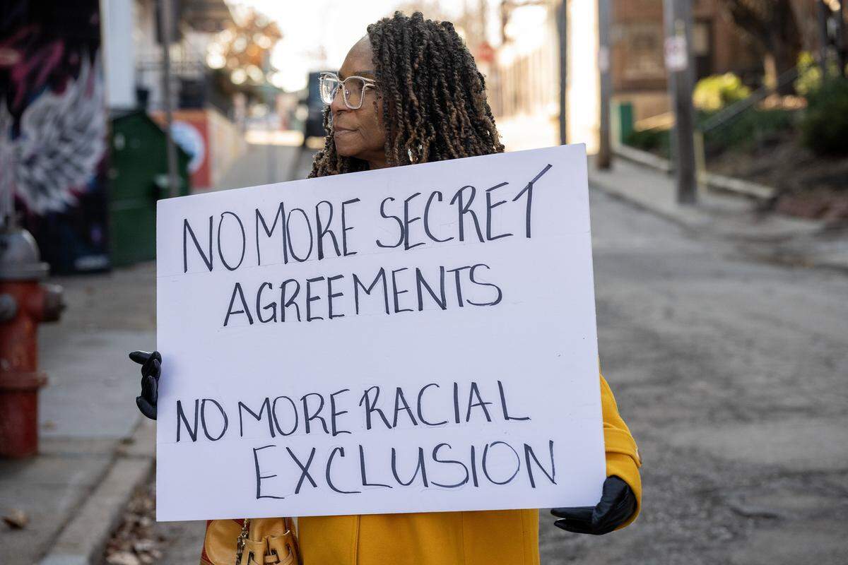 A community member holds a sign during a press conference outside Holy Brunch on Monday, Dec. 8, 2025, in Kansas City. The event, organized by the Urban Council and other Black community organizations, addressed allegations of racial discrimination against Black-owned businesses in the Westport neighborhood.