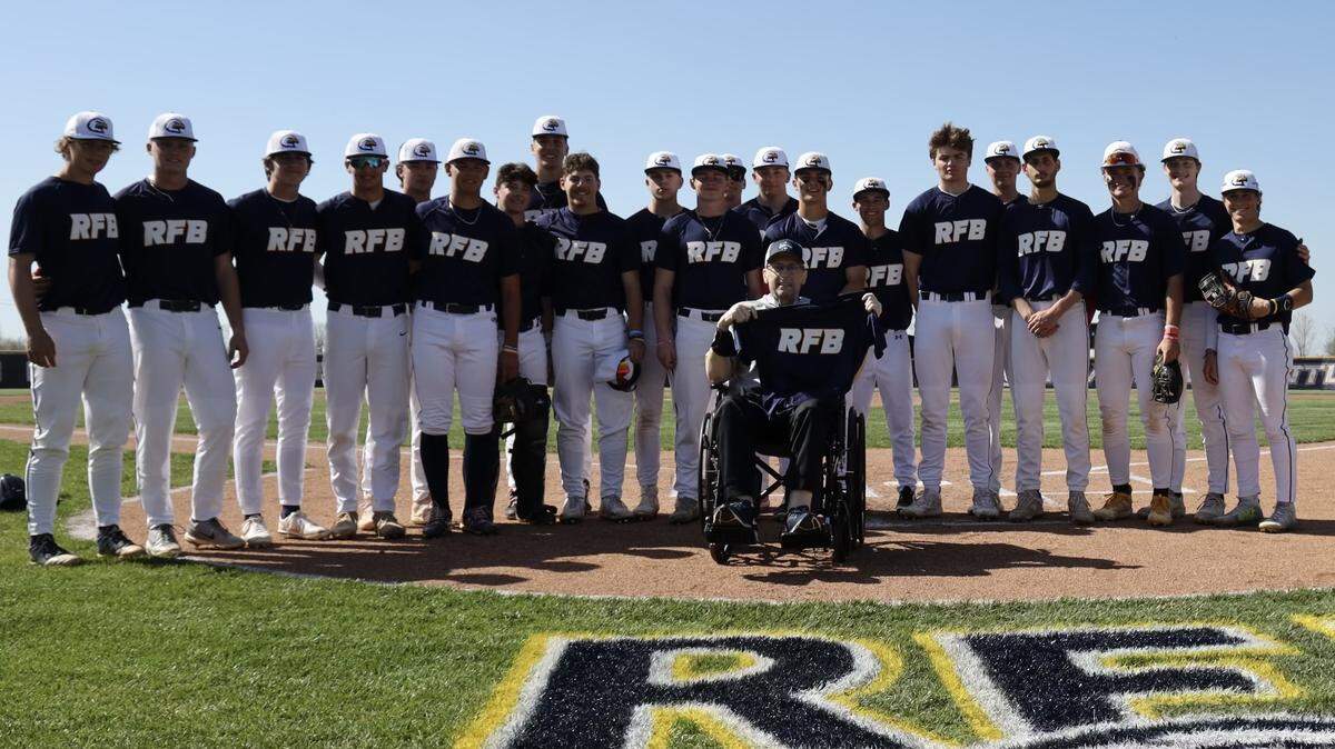 Liberty North coach Rob James holds up Ready For Battle (RFB) jersey in front of his players during Fight for a Cure game against Blue Spring South in April.