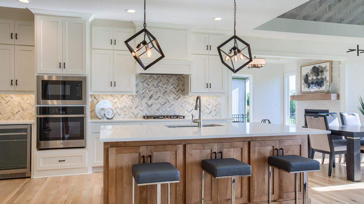 Inspired by open-concept living, The New Haven by Rodrock Homes is a 1.5-story reverse beauty by Rodrock Homes with a gourmet kitchen and expansive walk-in pantry, covered porch off the living room with access from the master suite, hearth room and bonus room perfect for a study or guest room. The home is scheduled for completion this summer. (Priced in the low $900,000s, MLS#2410530)