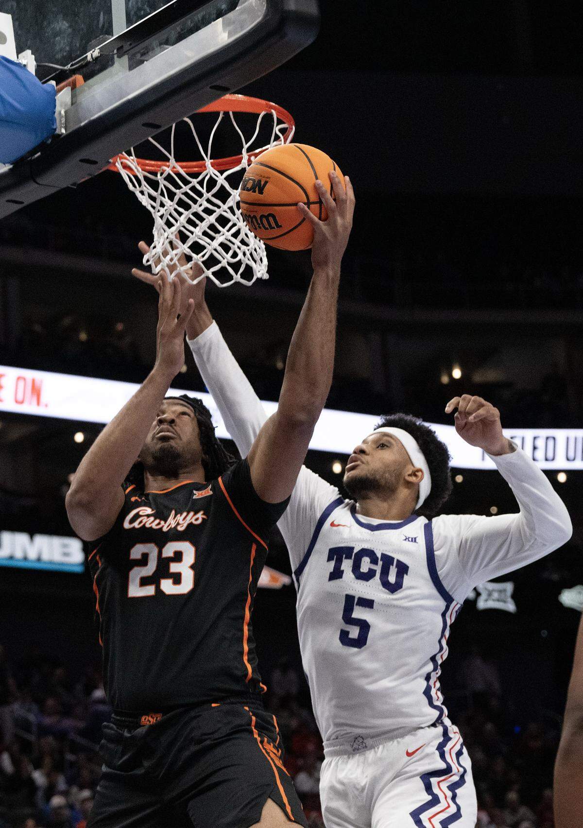 Oklahoma State Cowboys center Benjamin Ahmed (23) goes for the ball as Texas Christian University Horned Frogs forward Micah Robinson (5) defends during the first half of the Big 12 Men's Basketball Tournament at T-Mobile Center on Wednesday, March 11, 2026, in Kansas City.