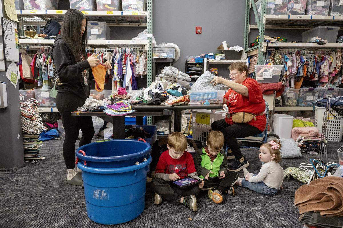 Volunteer Emilee Vasquez (left) sorts underwear, while Kelly Patterson, volunteer coordinator for the Starfish Project, organizes other donations while her three grandchildren-Jeremiah, 6, Timothy, 4, and 14-month-old Lilah, occupy themselves on Thursday, Feb. 12, 2026, in Olathe. The Starfish Project is a nonprofit that provides essential items free of charge to those in need. The organization has recently received notice that it must relocate.