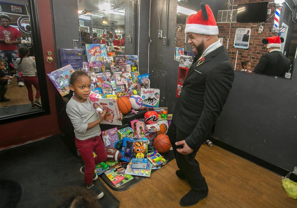 Draque Murff, owner of Draque’s Barbershop, 106 W. 39th St., and staff donated food, haircuts and over 100 toys to Kansas City kids at his Holiday Harvest Toy Drive.