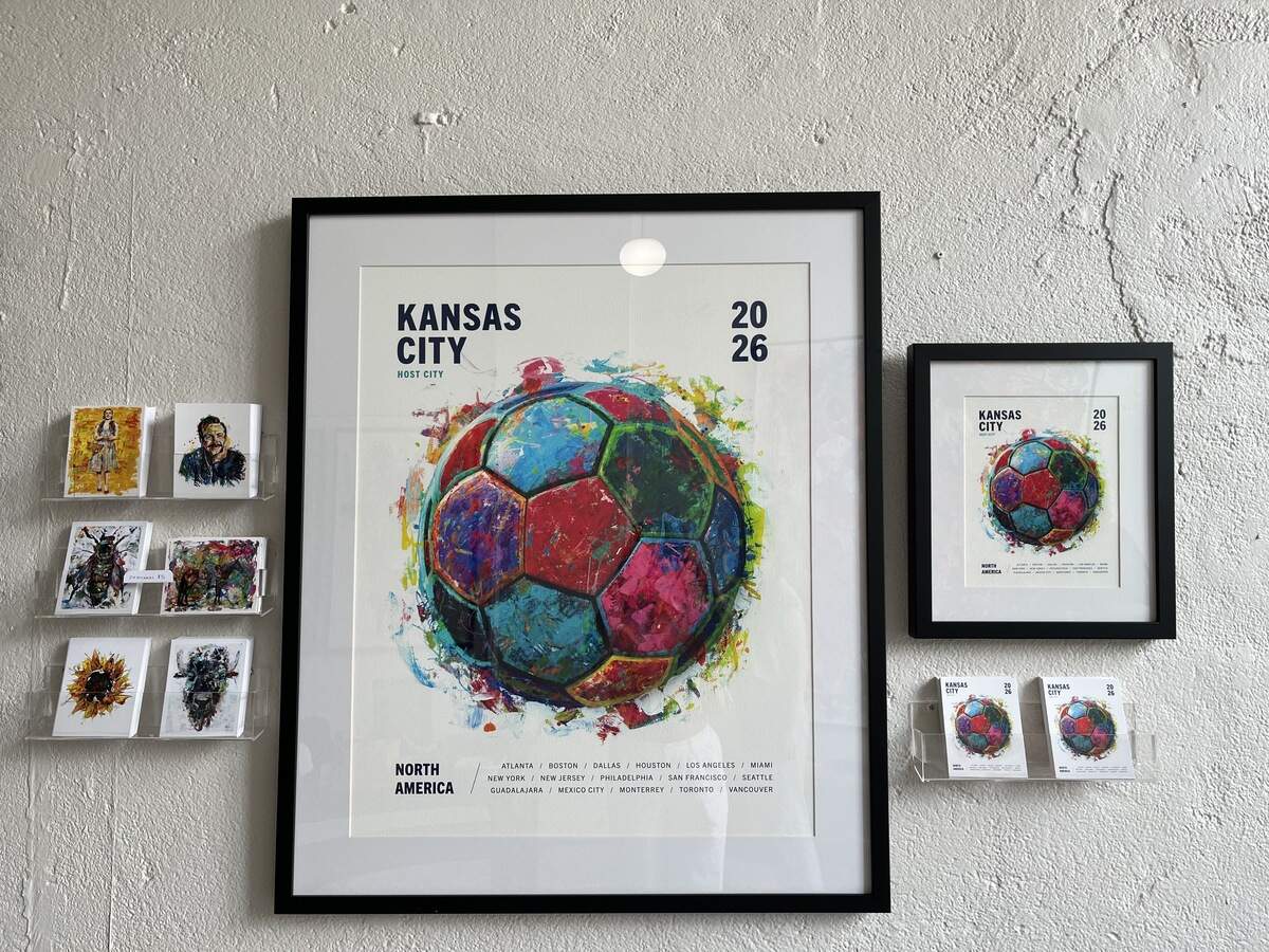 Megh Knappenberger’s World Cup poster design, framed on the wall in her new gallery and shop at 108 E Missouri Ave.