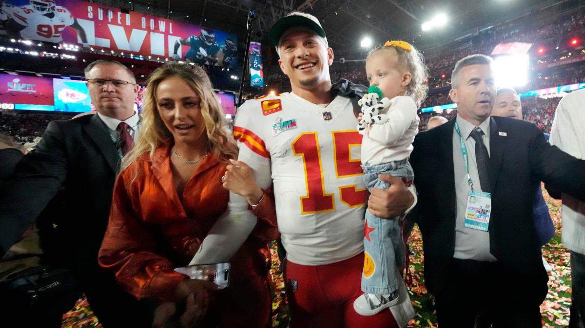 Kansas City Chiefs quarterback Patrick Mahomes (15) walks off the field with his wife Brittany and daughter Sterling after defeating the Philadelphia Eagles in Super Bowl LVII at State Farm Stadium.