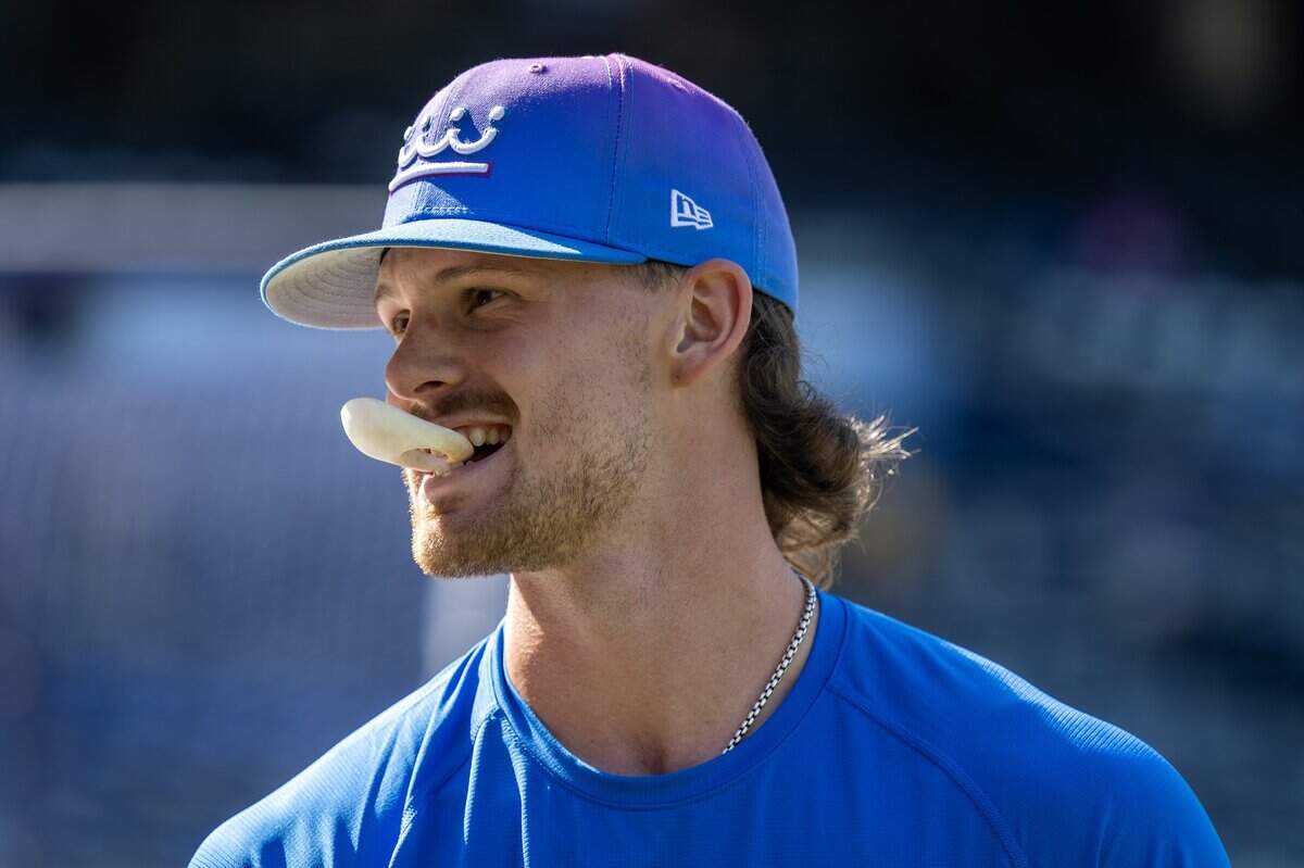 Kansas City Royals shortstop Bobby Witt Jr. (7) holds a batting accessory in his mouth during batting practice before a baseball game against the Houston Astros on Friday, June 12, 2026, at Kauffman Stadium in Kansas City.