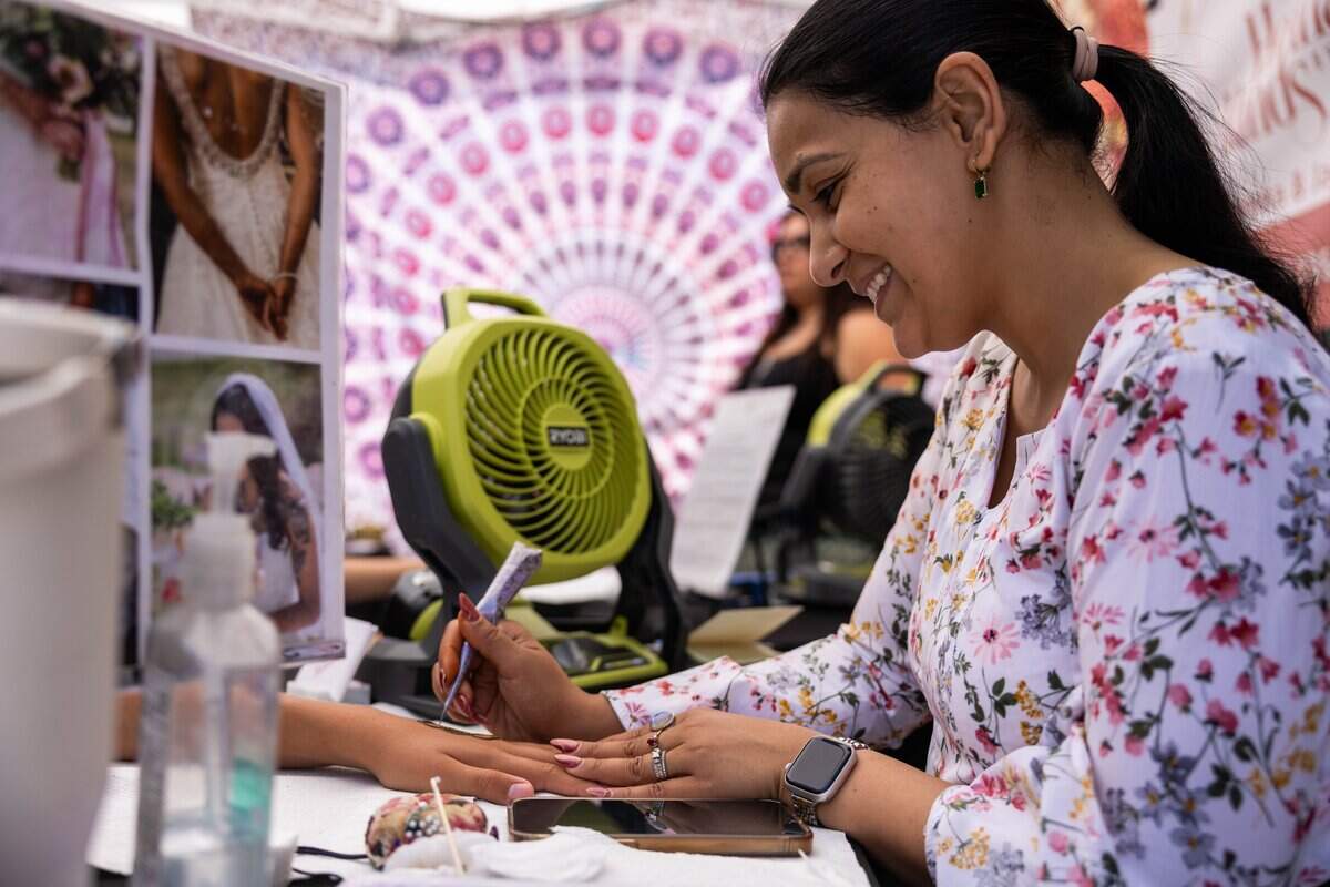 Nida Syed-Sardou, professional henna artist, and owner of Henna Hands by Nida draws on a customers hand during JuneteenthKC 15th Annual Heritage Festival at E 18th Street on Saturday, June 20, 2026. Syed-Sardou won Best of Pitch KC for the Henna Category in 2022 and 2023.