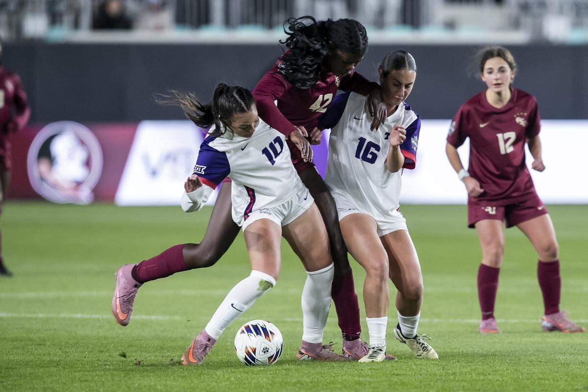 TCU midfielder Kamdyn Fuller (No. 10) and midfielder Cate Sarinopoulos (No. 16) attempt to shield the ball from Florida State forward Wrianna Hudson (No. 42) during a College Cup NCAA Division I women’s soccer semifinal match at CPKC Stadium in Kansas City, Missouri on Friday, Dec. 5, 2025. The Seminoles beat the Horned Frogs to advance.