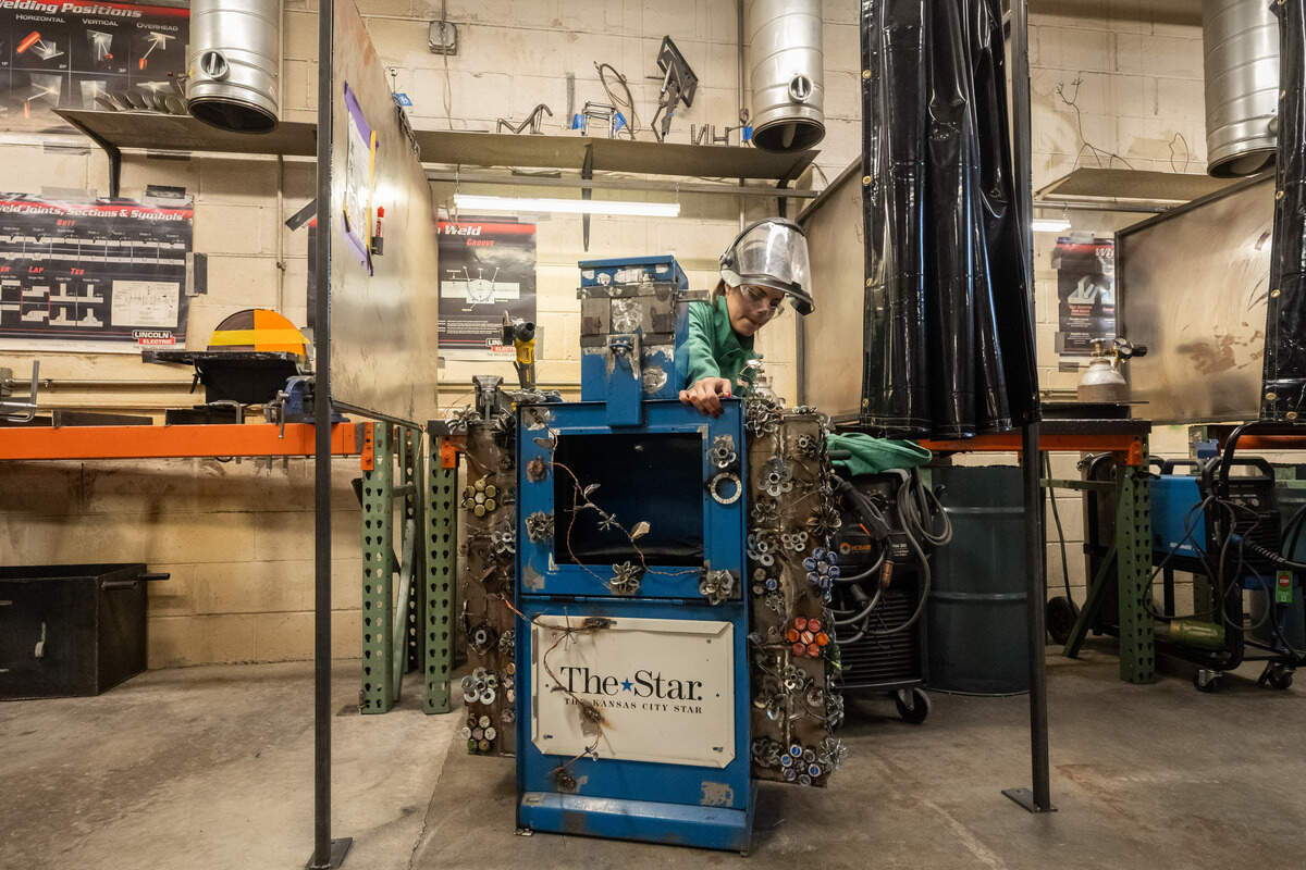 Student welders are repurposing old newspaper boxes as functional art pieces to distribute information about schools around the city.