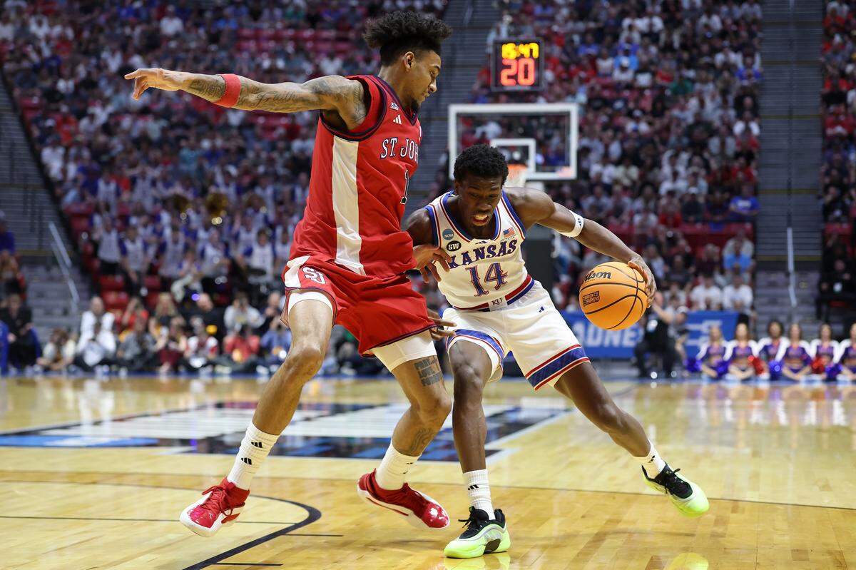 Melvin Council Jr. #14 of the Kansas Jayhawks drives to the basket against Dillon Mitchell #1 of the St. John's Red Storm during the first half in the second round of the 2026 NCAA Tournament at Viejas Arena on March 22, 2026 in San Diego.