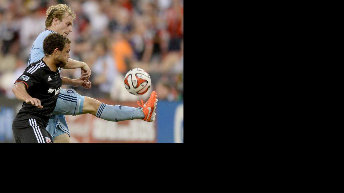 
Sporting KC defender Seth Sinovic (15), back, plays the ball away from D.C. United midfielder Nick DeLeon (14) in the second half at RFK Stadium in Washington, Saturday, May 31, 2014. United defeated Sporting KC, 1-0. 
