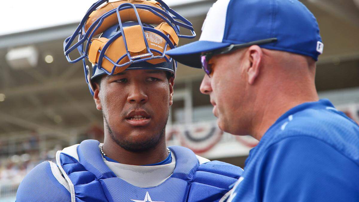 Kansas City Royals catcher Salvador Perez listens to bench coach Pedro Grifol between innings of a spring training baseball game against the San Diego Padres Wednesday, March 11, 2015, in Surprise, Ariz. (AP Photo/Lenny Ignelzi)