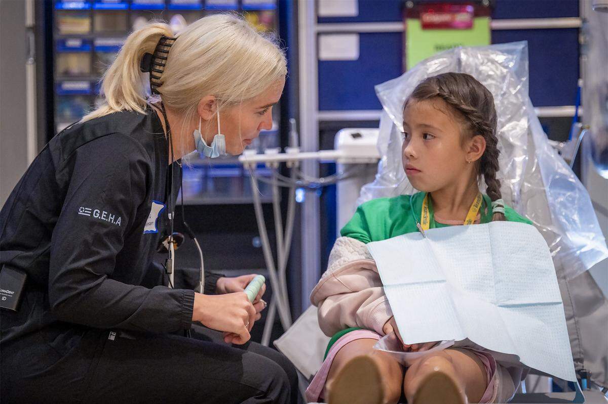 Emma Feldmann, a dentist from St. Louis, talks with Ixel Anabel Sarmiento-Rodriguez, 9, of Kansas City, before some free dental work done on Khloe at the TeamSmile dental tailgate on Tuesday, Sept. 9, 2025 at GEHA Field at Arrowhead Stadium. More than 200 volunteer dentists, hygienists, and dental assistants provide the free care for 300 Kansas City and Kansas City, Kansas school children backed by TeamSmile and the Chiefs.