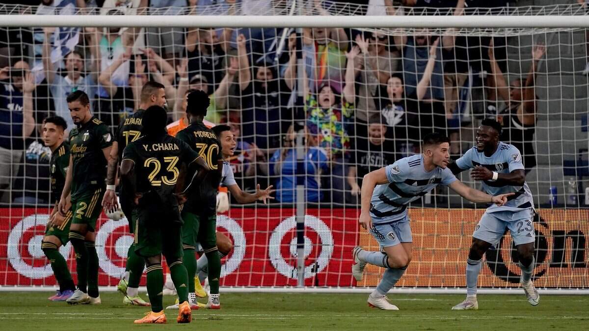 Sporting Kansas City defender Andreu Fontàs, second from right, celebrates with forward Willy Agada after scoring during the first half of Sunday night’s home match against the Portland Timbers.