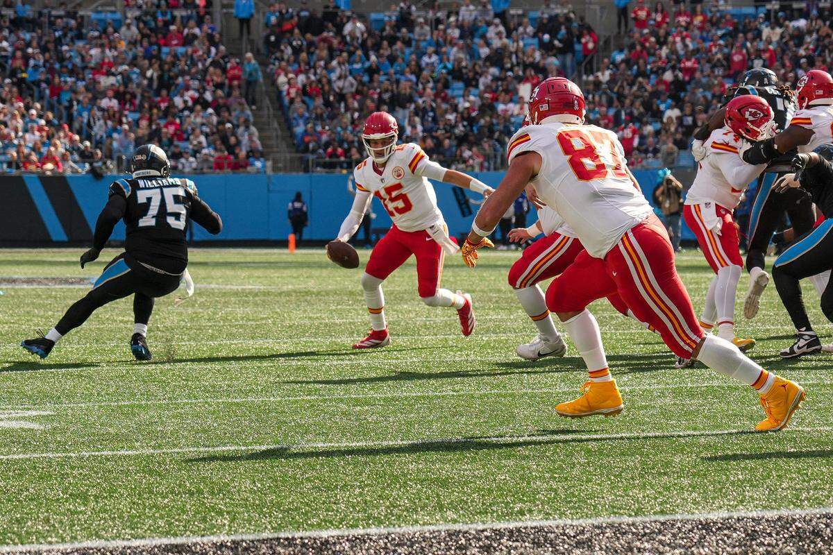Kansas City Chiefs quarterback Patrick Mahomes (15) runs with the ball while chased by Carolina Panthers defensive tackle DeShawn Williams (75) during the first quarter at Bank of America Stadium.