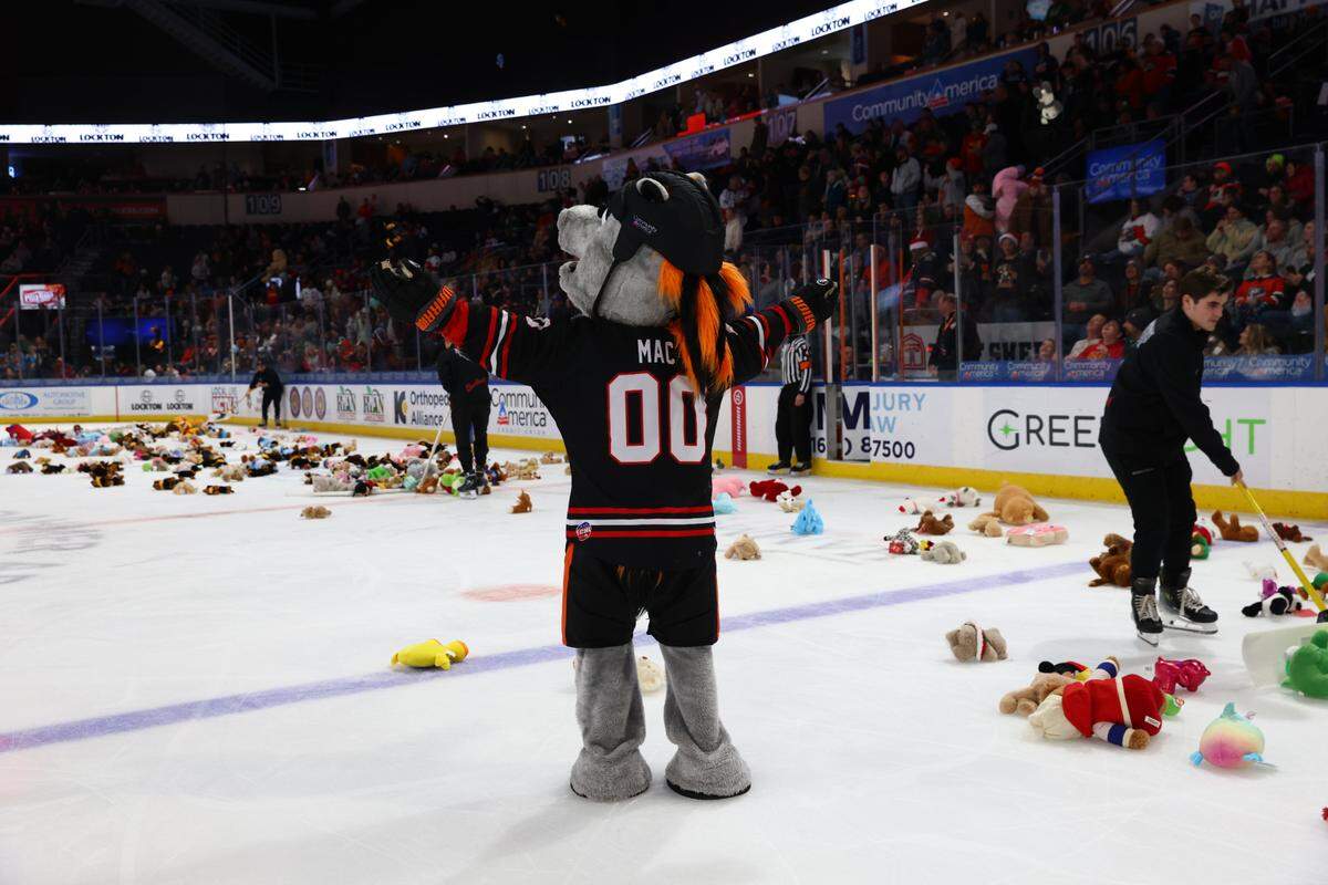 The Kansas City Mavericks mascot stands among teddy bears thrown onto the ice by fans in attendance at Cable Dahmer Arena.