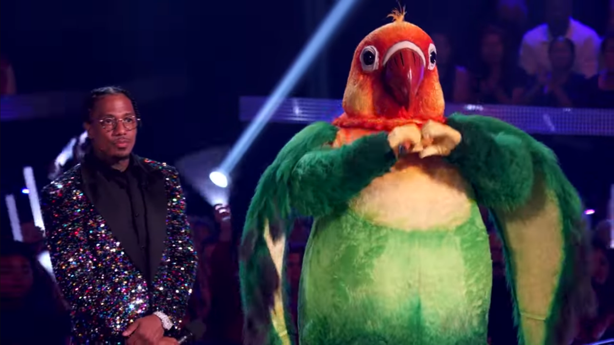 “The Masked Singer,” hosted by Nick Cannon, left, debuted Wednesday with Lovebird as one of the new celebrity contestants. Judge Ken Jeong suggested that Chiefs tight end Travis Kelce is Lovebird.
