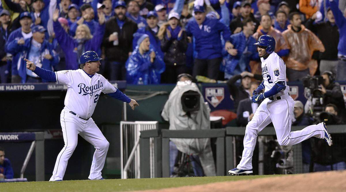 Kansas City Royals third base coach Mike Jirschele waves shortstop Alcides Escobar home after Escobar hit an inside the park home run off the first pitch of the bottom of the first inning during Game 1 of the World Series on Tuesday, October 27, 2015 at Kauffman Stadium in Kansas City, Mo.