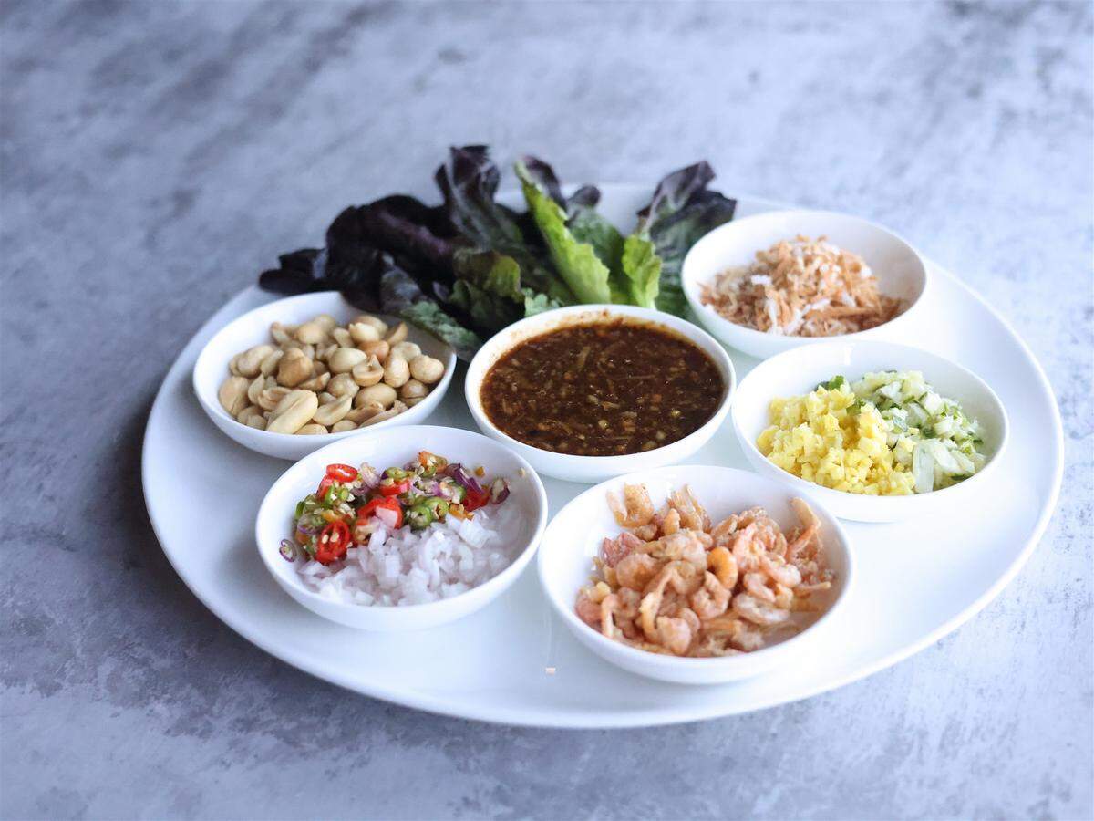 One appetizer, the miang khum, comes with betal leaf wraps that customers top with dried shrimp, toasted coconut, peanut, ginger, shallot, lime, Thai chili, fermented shrimp paste and palm sugar. ​