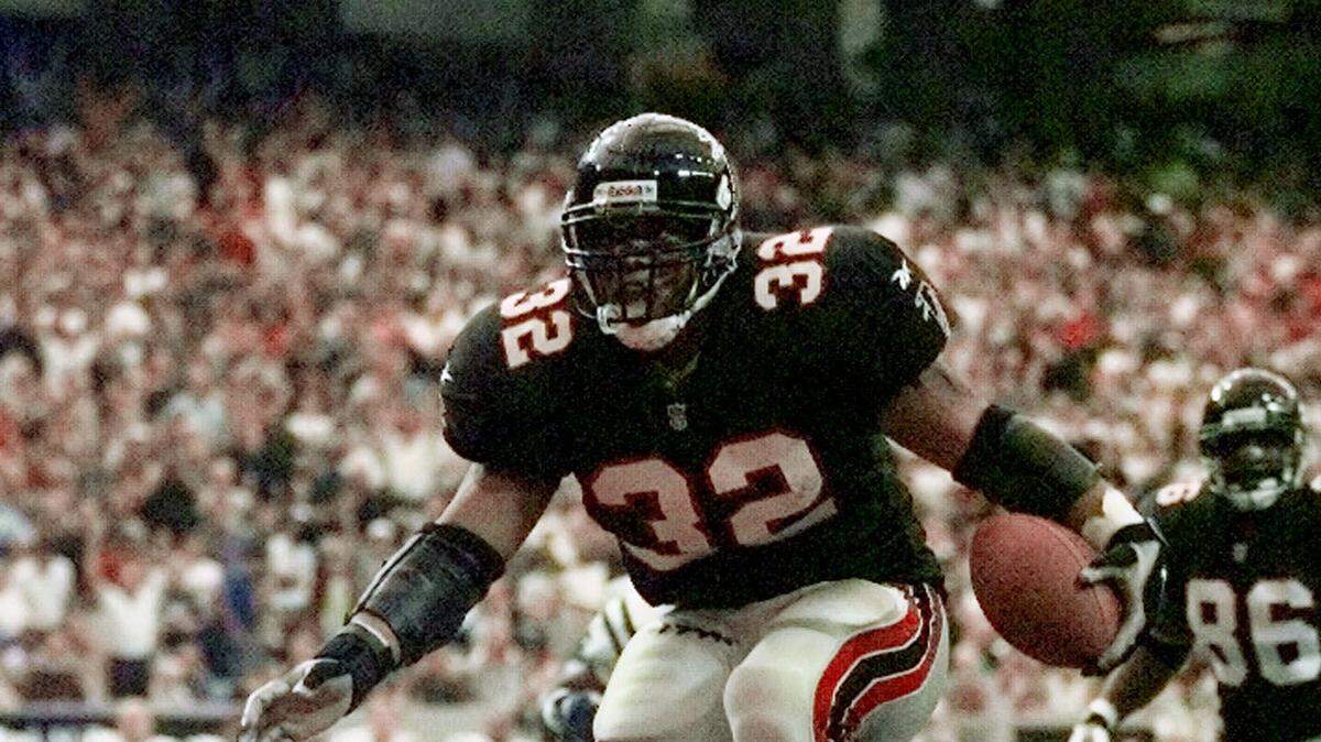 Atlanta Falcons Jamal Anderson (32) jumps to a touchdown over fallen Indianapolis Colts Jeff Herrod (54) Michael Barber (53) and Larry Chester (64) during the first half in Atlanta, Sunday, Dec. 6, 1998. (AP Photo/John Bazemore)