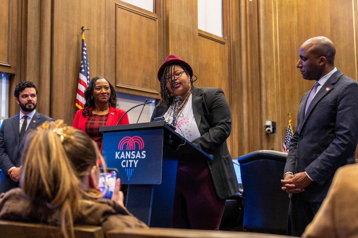Flanked by, from left, City Council members Jonathan Duncan and Ryana Parks-Shaw and Mayor Quinton Lucas, Melissa Ferrer Civil recited a poem as the city’s new poet laureate on Thursday.