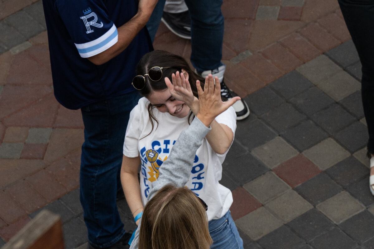 Fans hi-five while watching the Royals opening playoff game vs. the Baltimore Orioles at the Power & Light District on Tuesday, Oct. 1, 2024. The Royals won the game 1-0.