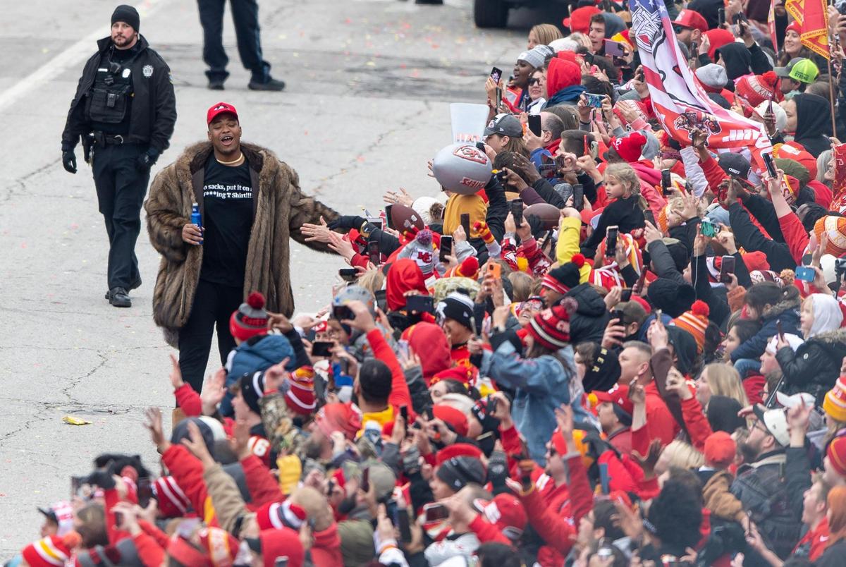Kansas City Chiefs offensive tackle Orlando Brown Jr. high fived fans during the Kansas City Chiefs Super Bowl victory parade Wednesday. His fur coat and Ugg boots were a fashion moment.