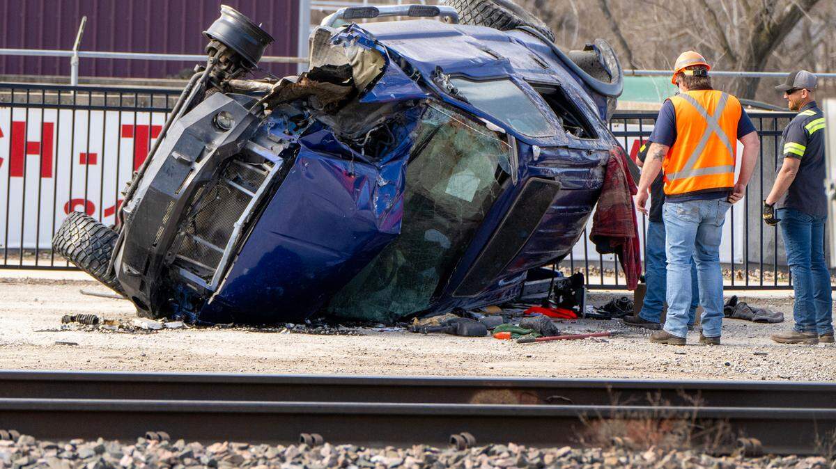Workers look over a truck that was struck by a train on Tuesday, March 18, 2025, near Northwest River Park Drive and the Missouri River Front Trail, just east of downtown Parkville. The truck’s driver suffered minor injuries.