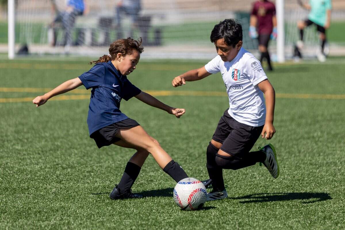 Members of team Guadalupe Center, left, and team Estrella De Oro fight for the ball during the first slate of matches at 901 Van Brunt Blvd on Saturday, July 11, 2026. The league, presented by CVS Health, aims to increase youth soccer participation, particularly among girls, while providing education for coaches and referees.