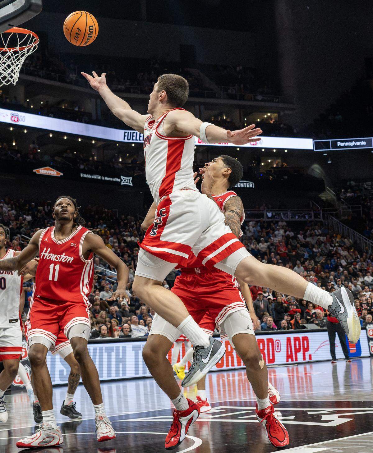 Arizona Wildcats forward Ivan Kharchenkov (8) makes a layup over Houston Cougars center Chris Cenac Jr. (5) during the second half of the Big 12 Men's Basketball Tournament Championship game at T-Mobile Center on Saturday, March 14, 2026, in Kansas City.
