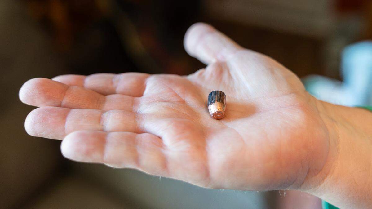 Stacie Matuszeski holds up a bullet fragment she said came crashing through the ceiling of her Independence home on New Year’s Day.