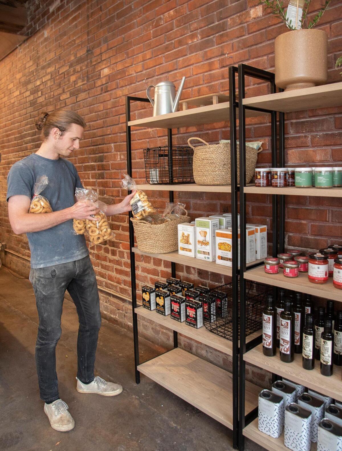 Zero Zero manager P.J. Meacham stocked shelves at the new West Side retail shop and production facility. 