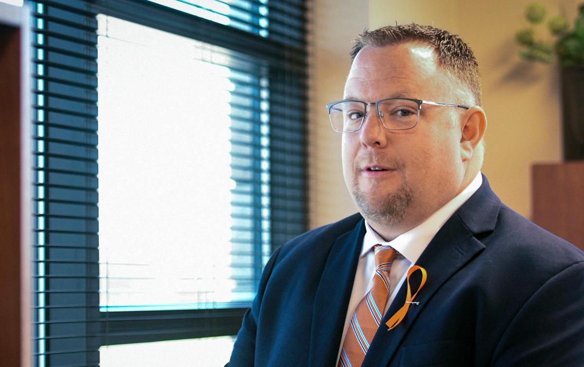Olathe Superintendent Brent Yeager wore an orange ribbon in support of Olathe East High School at his office on Wednesday.