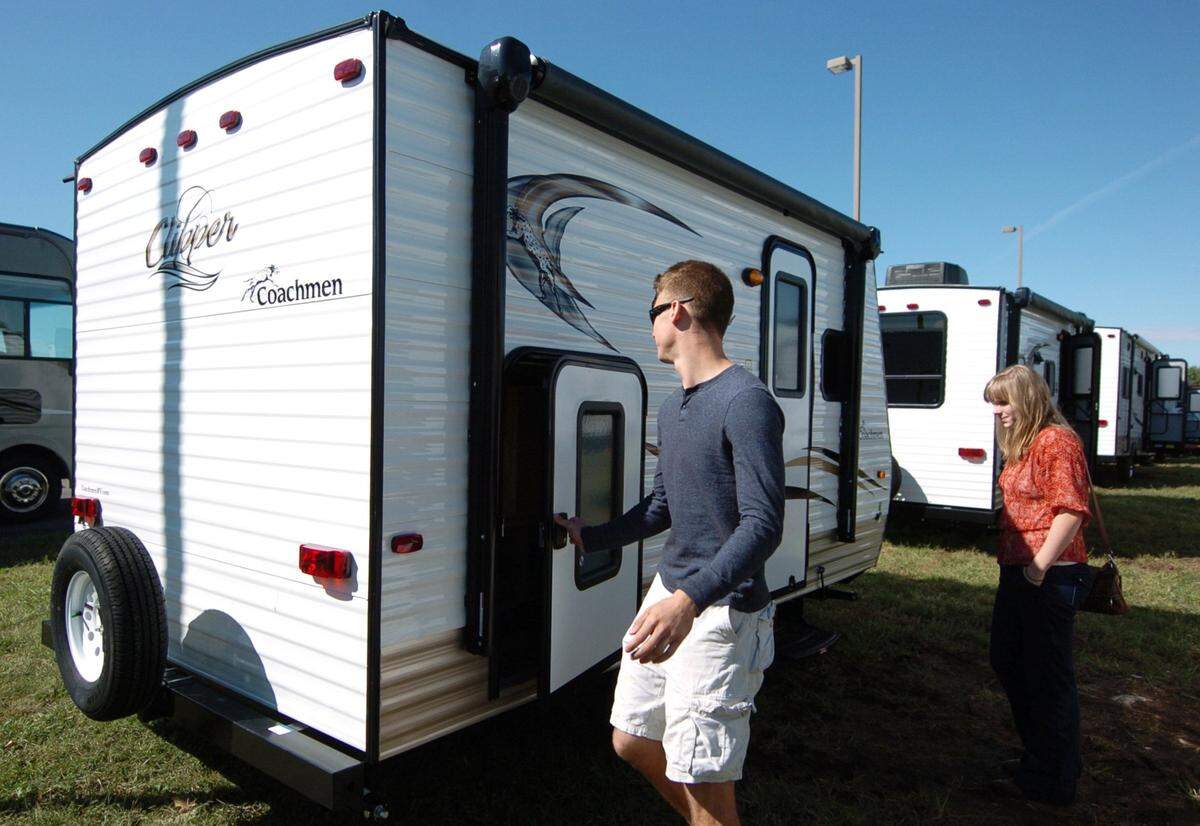 A couple examines a camper travel trailer they were in the process of purchasing in September 2015 in Gardner. Such trailers that are hooked onto cars do need to be registered in the state of Kansas.