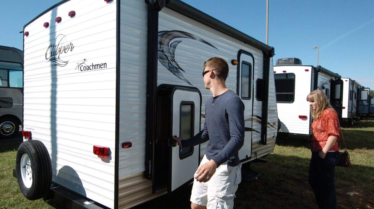 A couple examines a camper travel trailer they were in the process of purchasing in September 2015 in Gardner. Such trailers that are hooked onto cars do need to be registered in the state of Kansas.