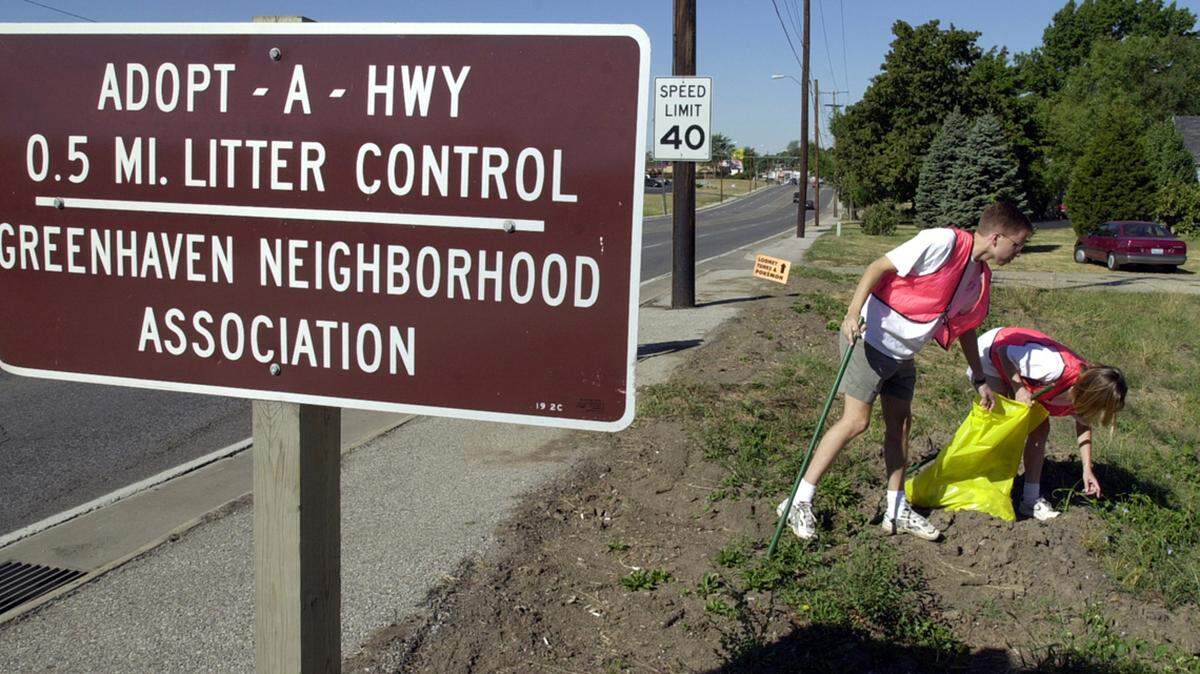 Keeping their neighborhood clean, Joe Vanover, and Keely Norris pick up trash while participating in the Greenhave Neighborhood Associations Adopt-A-Highway litter control project along Vivion Road in Kansas City, North.